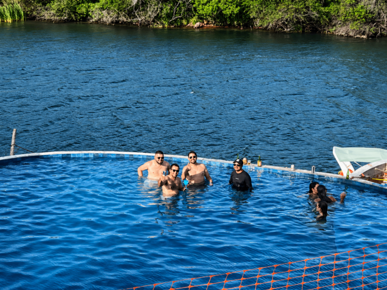 Amigos relaxando na piscina à beira do rio